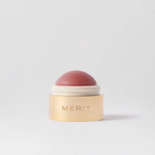 Cosmetic product with 'MERIT' branding on a light gray background