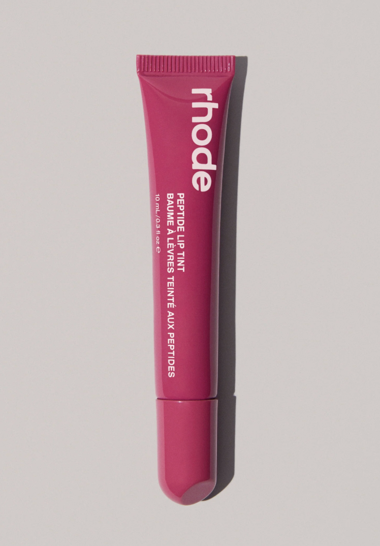 A pink squeeze tube of Rhode Peptide Lip Tint on a light gray background with a soft shadow.