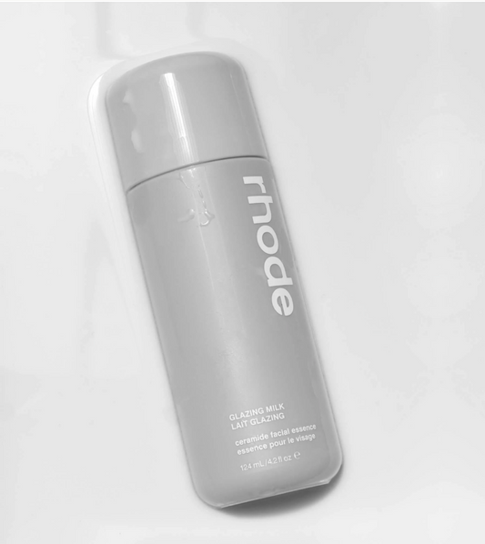 A bottle of Rhode Glazing Milk facial essence, shown at an angle on a clean white background.