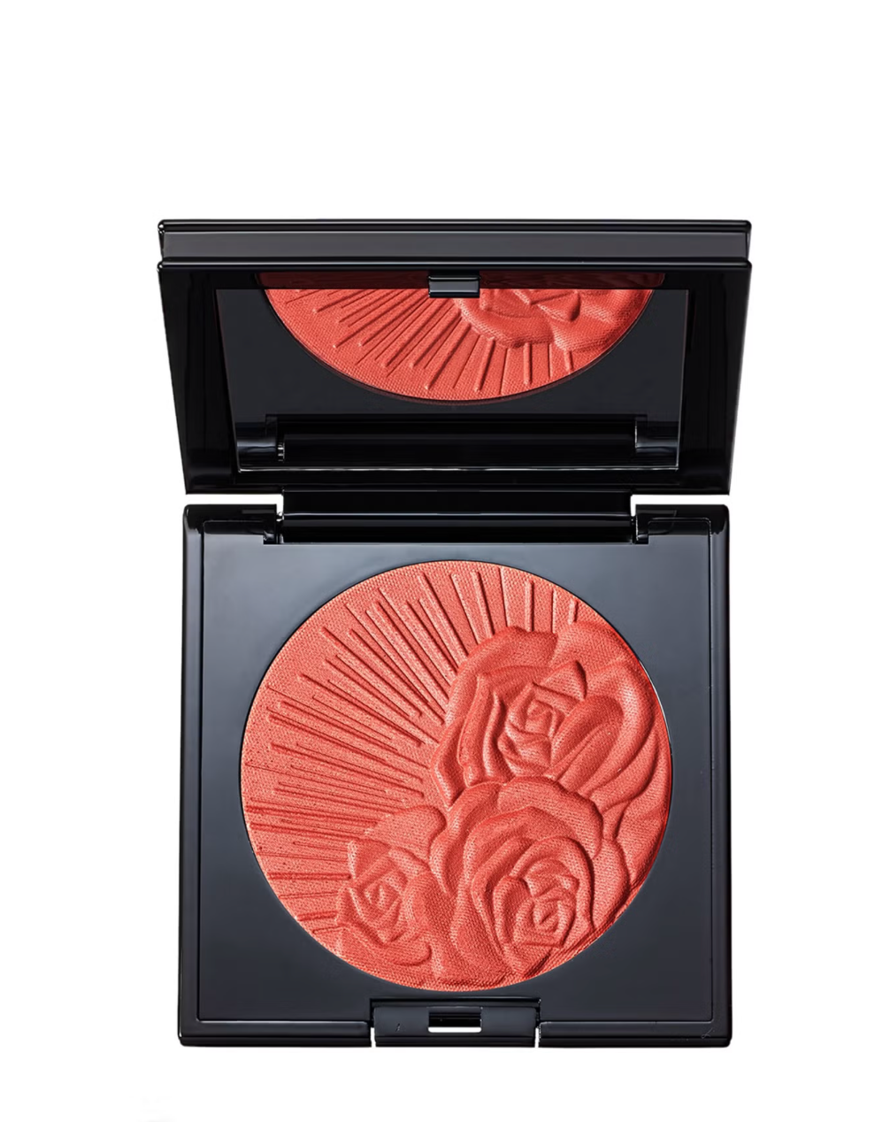 An open black makeup compact showing a circular pressed powder blush in a warm coral-orange shade with embossed rose details, on a plain white background.